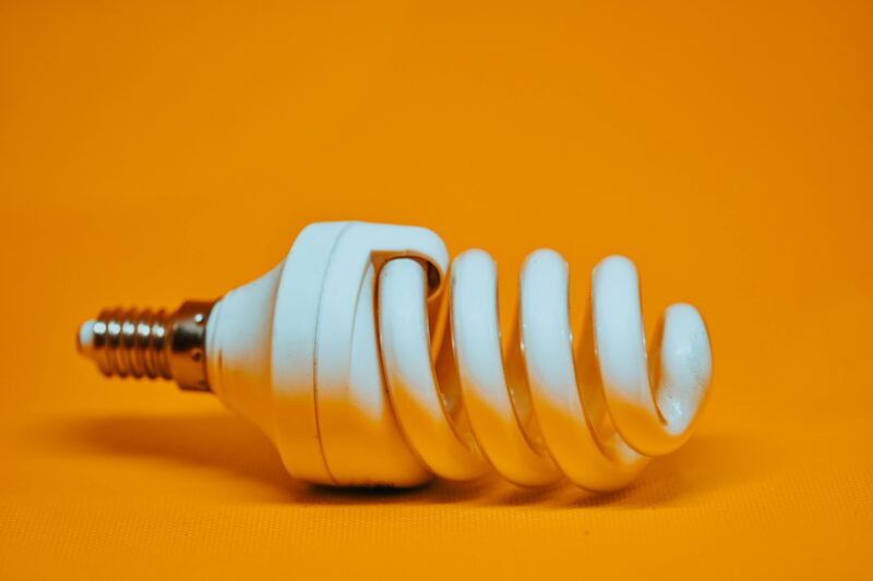 lâmpada LED em um fundo laranja para representar a economia