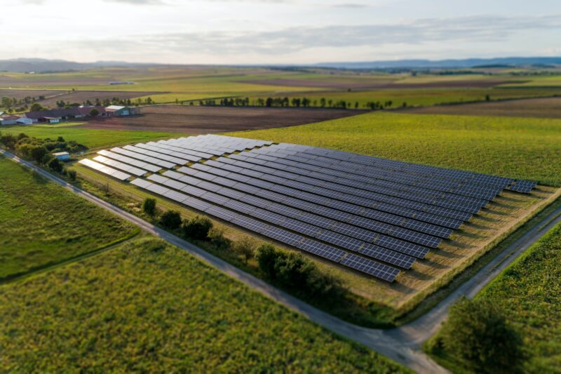 Painéis de energia solar instalados no solo de uma fazenda para representar a operação de barter solar.