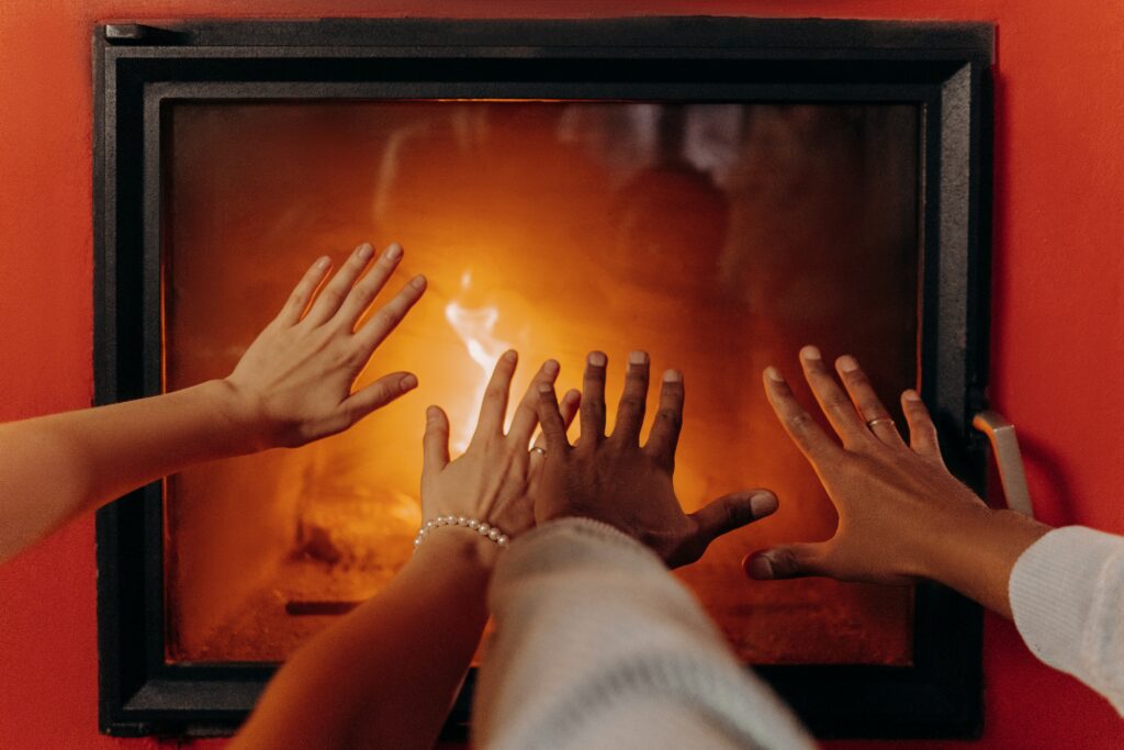pessoas aquecendo a mão para representar o consumo de energia no inverno