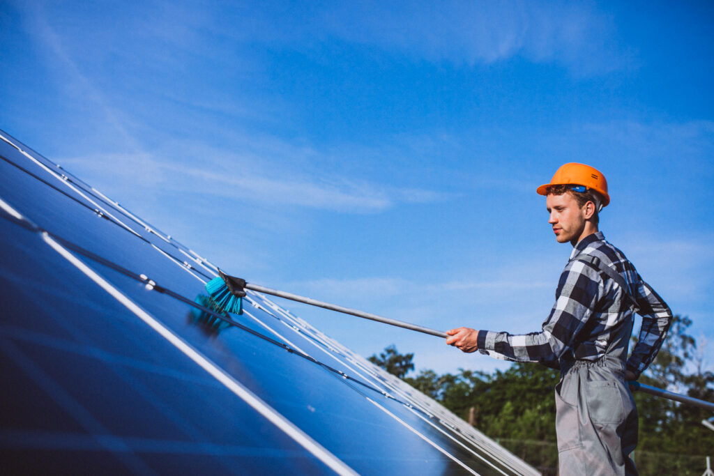 homem fazendo manutenção em um painel solar para representar um dos motivos para investir em energia solar