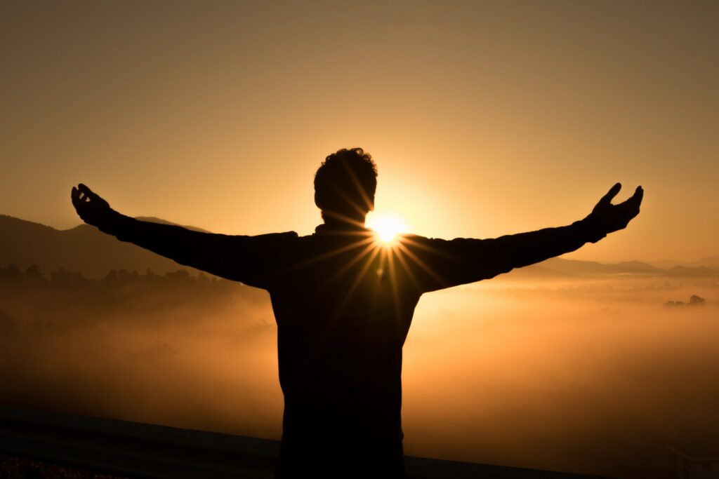 imagem de um cara com braços abertos para o sol, representando a liberdade do mercado livre de energia